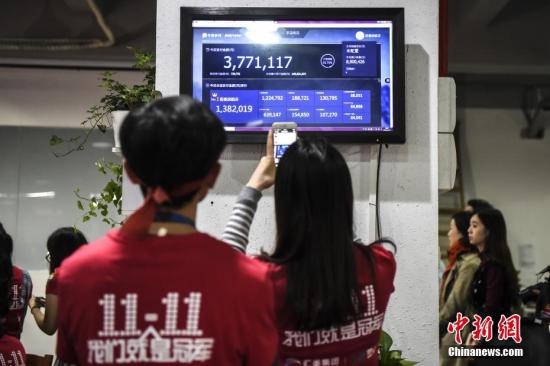资料图：11月11日，广州海珠创意产业园内的一家电商企业办公室灯火通明，员工关注交易量。11日零时，一年一度的双十一网购狂欢节正式拉开帷幕。